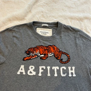 A&F sweater - En sweater med motiv från abercrombie & fitch i storlek L ”muscle fit” vilket motsvarar en M vanlig storlek. E21. Jag skickar alltid inom 24h! Se fler liknande zip tröjor i min profil! 