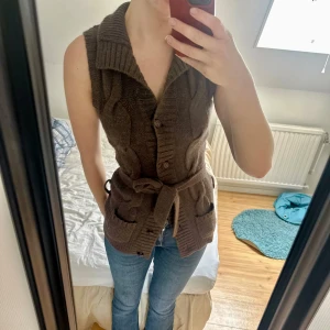 Brun stickad väst med bälte - Mysig brun stickad väst med grov kabelstickning. Skriv vid frågor🩷