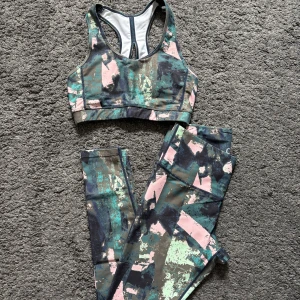 Träningsset - Grönt och rosa set med träningstajts samt matchandde topp. Tajtsen är i storlek M och toppen i S.