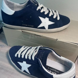 Golden Goose SUPER-STAR - PRESENTERAR: Golden Goose mörkblå superstar i storlek 42 (41-42) Kanske de fetaste skorna ute på plick just nu? Skick: 9/10 inga defekter helt nya knappt använda!! Nypris: 6000kr ALLT OG ingår. Hör av er vid frågor 👍🔥💫