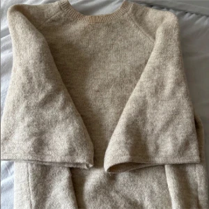 Beige stickad tröja från Gina Tricot - Supermjuk och basic beige stickad tröja från Gina Tricot. Rund halsringning, långärmad och i en skön, lite loose passform. Perfekt att slänga på sig när det är kyligt ute. Enkel att matcha med allt i garderoben.