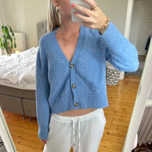 Blå ribbad kofta med knappar - Superfin ljusblå kofta med ribbat stickat material.