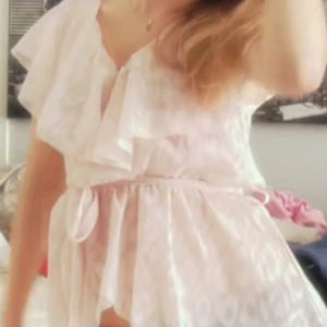 Ljus blus med volang och knyt - Supersöt ljus blus med volangdetaljer och knyt i midjan. Blusen har v-ringning och är ärmlös, perfekt för varma dagar. Tunt och luftigt material som ger en romantisk vibe. För mer bilder är det bara att fråga!