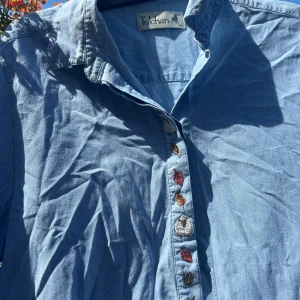 Blå skjorta med lövdetaljer  - Används ej längre, jag städar ut min garderob :)