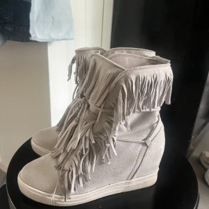 Gråa frans skor! - Unika sneakers med fransdetaljer och snörning framtill. Skorna har en dold kilklack för extra höjd. Perfekta för dig som vill sticka ut med en cool och bohemisk stil. Storlek 36!
