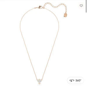 Rose gold halsband med ängelberlock - Supersött halsband med en liten ängelberlock dekorerad med gnistrande stenar. Kedjan är tunn och justerbar, perfekt för att ge en subtil men ändå personlig touch till din stil. Passar dig som gillar detaljer och vill ha något unikt runt halsen.