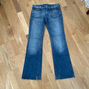 Blåa jeans - Supersnygga lågmidjade bootcut jeans i färgen blå! Vintage och går inte att få tag på längre! Storlek 26, midja: 35 cm, midjehöjd: 20 cm, innerben: 74 cm