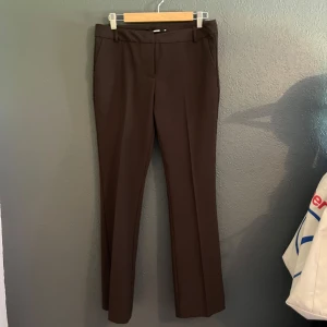 Bruna kostymbyxor från BikBok, stl 40 - Pw Vera seasonal, lågmidjade bruna kostymbyxor från Bikbok.  Flare Utsvängda ben Semi stretch Fickor i sidan Low waist Normal längd Dragkedja och knapp Enfärgad  Aldrig använda, endast testade!  Nypris 599kr