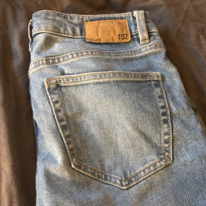 Blå jeans från 157, storlek XS short - Snygga ljusblå jeans från 157 i storlek XS short. Klassisk femficksmodell med raka ben och normal passform. Jeansen är tillverkade i bomull och har en enkel, tidlös look som passar till det mesta. Perfekta för dig som gillar en avslappnad stil. har inte använt så mycket