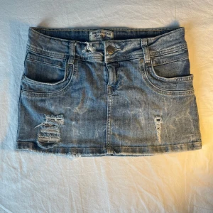 Blå jeanskjol från Bershka denim  - Super snygg low waist blå jeanskjol med slitna detaljer  från Bershka denim 💗 Inte använd överhuvudtaget ❤️ Priset kan diskuteras 