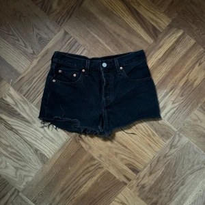 Svarta jeansshorts från Levi's - Svarta jeansshorts från Levi's med råa kanter och klassisk femficksdesign. Jag är ca 160 för referens. ♣️storlek W25 