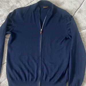Stenströms merinoull fullzip färgen navy strl: L  - Säljer nu min Stenströms fullzip då den har blivit för liten. Den är i 9/10 skick, står att den är l men det passar bäst ifall du har m . Har tyvärr inget kvitto men den är köpt på Stenströms hemsida. Dma vid fler frågor:)