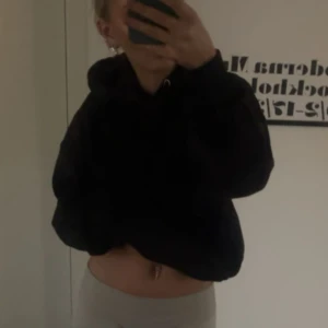 Svart hoodie från BikBok - Säljer en svart hoodie från BikBok i storlek XS. Tröjan har huva med dragsko och ribbade muddar vid ärmslut och nederkant. Perfekt för en avslappnad och bekväm stil.