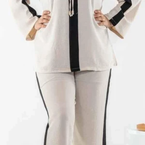 Beige byxor med svarta ränder med blus. - Snygga beige byxor med raka ben och svarta ränder längs sidorna. Byxorna har en avslappnad passform och är perfekta för en trendig och bekväm stil. Har en passande blus med byxan som följer med.