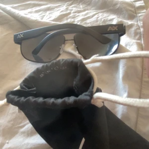 Svarta solglasögon från Armani Exchange - Snygga svarta solglasögon från Armani Exchange med breda skalmar och AX-logga på sidorna. Inga repor eller skador.