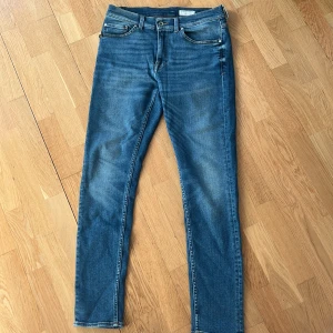 Blå jeans från Tiger of Sweden - Säljer ett par klassiska blå jeans från Tiger of Sweden. Jeansen har raka ben och normal passform. Snygg tvätt med lätt slitning och detaljerade sömmar. Perfekta för en stilren look. Priset är diskuterbart vid smidig affär.✨