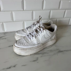 Vita Nike sneakers - Klassiska vita Nike sneakers. Kan torka av sulan men den ska va i lite benigare färg än själva skon