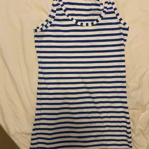 Linne - Blå/vit randigt linne i längre modell. Nyskick! Tyvärr var det lite mörkt när bilden togs men färgerna är klara. Passar även gravidmagen. 