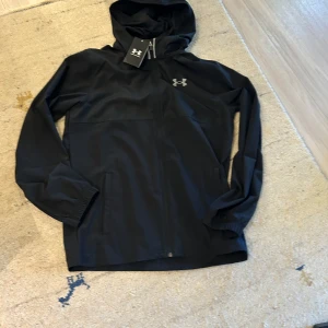Under Armour Vanish jacka - Under Armour vanish jacka som är mycket populär just nu säljer jag helt ny med prislapp pga att den va lite stor för mig. Jackan är slutsåld i butik