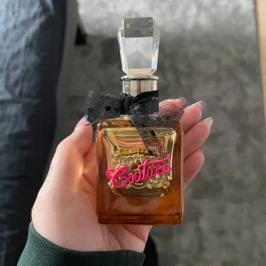 Viva la juicy parfym - Säljer en lyxig parfym från Juicy Couture. Flaskan har en svart rosett och en guldfärgad detalj med rosa texten 'Couture' framtill. Det är ca 28 ml kvar utav 30 ml.