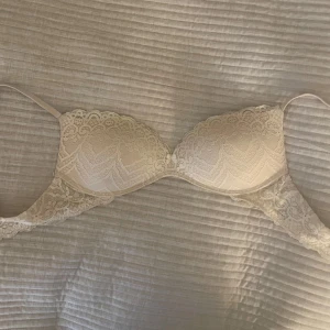 Beige spets-bh från Intimissimi - Säljer en beige bh från Intimissimi i strl S/M. Förra ägaren visste inte storleken och jag säljer då den var förstor för mig. Bh:n har justerbara axelband. Det finns även några små fläckar på insidan som knappt är synliga (kolla tredje bilden) 