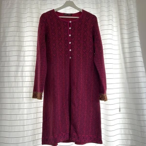 Kofta från Gudrun Sjödén - Röd/rosa kofta från Gudrun Sjödén med dekorativt mönster och långa ärmar. Koftan har rund halsringning, knappar framtill och kontrasterande detaljer vid ärmslut och nederkant. Nyskick, endast lappen inuti som är märkt med namn 