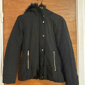 Svart vinterjacka - En lite tunnare vinterjacka men lika fin ändå! Svart fejkpäls kring kragen!