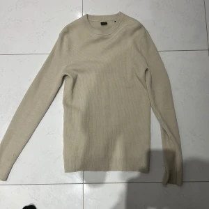 Beige ribbad tröja från ONLY & SONS - Säljer en stilren beige ribbad tröja från ONLY & SONS. Tröjan har lång ärm och rund halsringning, perfekt för lager-på-lager eller som den är. Enkel och tidlös design som passar till mycket.