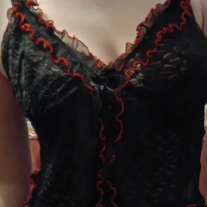 Svart och röd see through klänning  - Säljer en sexig svart och röd see through klänning. Är tyvärr lite sönder på baksidan då volangen inte sitter fast.