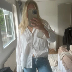 Vit skjorta från Lindex - Säljer en klassisk vit skjorta från Lindex i storlek M. Skjortan har lång ärm, krage och knäppning framtill. Passformen är lite oversized och materialet känns lätt och luftigt, perfekt till jeans eller kjol.