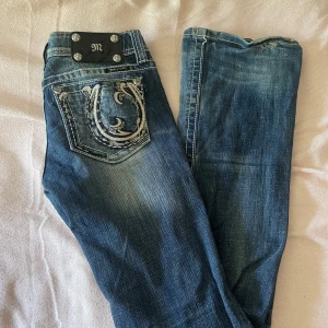 Lågmidjade bootcut jeans från Miss Me - Lågmidjade bootcut jeans från Miss Me. Storlek 26, och lite långa på mig som är 166. Skriv om ni vill ha mått. Fint skick, utom slitningar nere på byxbenen (Se bild 5!), men ingenting man tänker på när jeansen är på. Skriv vid frågor/ funderingar/ fler bilder. Priset kan alltid diskuteras💕Säljer även ett till par Miss Me jeans i min profil, så kolla in dem också!😄