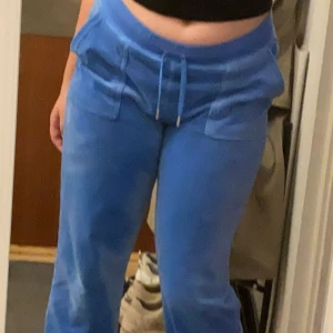 Blå Juicy Couture Skydiver - Säljer ett par blå mjukisbyxor från Juicy Couture med dragsko i midjan och fickor både fram och bak. Byxorna har en rak passform och är perfekta för en avslappnad stil. Mjukt material som känns skönt mot huden.
