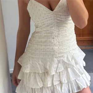 Volangklänning H&M - Superfin klänning till alla tillfällen! Oanvänd💘Perefekt till sommaren och fest. Vit med guldiga detaljer samt volang nertill.