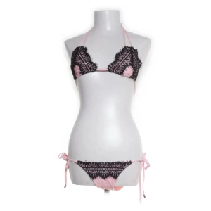 Svart och rosa bikini  - Trendig bikini från Elsa & Rose i svart och ljusrosa. Överdelen har virkade svarta detaljer över rosa tyg och knyt i nacke och rygg. Underdelen är rosa med svarta virkade detaljer framtill och knyt i sidorna. Nederdel och överdel för 400. Eller 300 kr styck. Säljer då den tyvärr tyvärr inte passar..