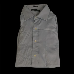 Ljusblå skjorta från Tommy Hilfiger - Klassisk ljusblå skjorta från Tommy Hilfiger med regular fit. Skjortan har långa ärmar, bröstficka och knäppning framtill med ljusa knappar. Perfekt för en stilren och enkel look.