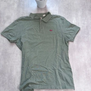 Grön pikétröja från Levi's - 💚Levi’s Piké – Avslappnad & Stilren Säljer en grön Levi’s pikétröja i storlek L. Klassisk krage, tre knappar framtill och liten röd Levi’s-logga på bröstet – enkel men snygg design.  🧵 Skick: Mycket bra 💸 Pris: Endast 99 kr!  En perfekt piké för dig som vill ha en bekväm och stilsäker vardagslook. 📩 Skicka DM om du vill köpa!