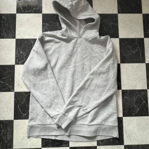 Grå hoodie - Grå hoodie från Gina Tricot i storlek M. Använd men fortfarande i fint skick, en aning nopprig på vissa ställen men inget som syns. Kolla gärna in mina andra annonser, jag vill bli av med allt och erbjuder paketpris!