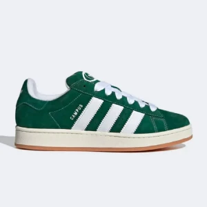 Adidas Campus gröna sneakers - Gröna Adidas Campus sneakers med vita ränder och vit sula. Skon har klassisk låg profil, snörning och ovandel i mocka. Perfekt för dig som gillar retrostil och vill ha en ikonisk sneaker i garderoben.
