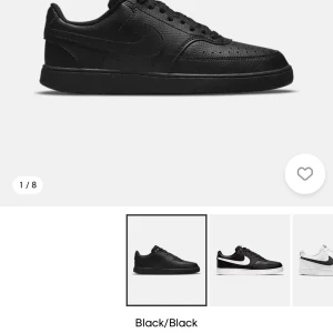 Svarta Nike  sneakers - Klassiska helsvarta Nike sneakers med rund tå och snörning. Skorna har en platt sula och är tillverkade i skinn med diskreta perforeringar på tån för ventilation. Perfekta för en stilren och sportig look.