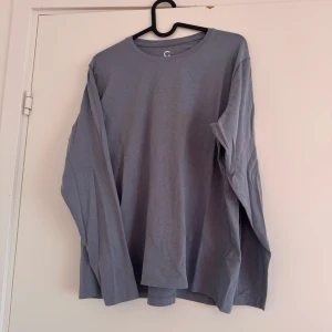 Gråblå långärmad t-shirt - Supermjuk långärmad t-shirt i en söt gråblå färg. Strl L med rak passform och är normal i storleken, så funkar även för strl M om man vill ha den lite lösare. I använt men gott skick. Säljes då den tyvärr inte kommer till användning <33