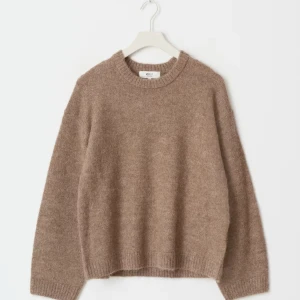 Beige stickad tröja från Gina  - Mysig beige stickad tröja från Gina  med rund halsringning och långa ärmar. Tröjan har en avslappnad passform och ribbade muddar vid ärmslut och nederkant. Perfekt för lager-på-lager under kyliga dagar. Den har inga defekter eller liknande 