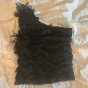 Svart one shoulder topp  - Snygg svart one shoulder topp med volanger från Stockh lm Studio. Perfekt fest topp och i väldigt bra skick! Har tyvärr ingen bild med den på men den är normal i storlek💕