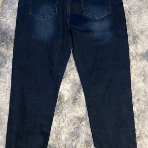 Mörkblå jeans från Dsquared2 - Säljer ett par mörkblå jeans från Dsquared2 med klassisk femficksdesign och raka ben. Jeansen har diskreta slitningar och kontrastsömmar. Tillverkade i 100% bomull och har en snygg, tidlös look.