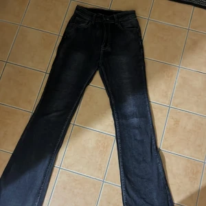 Svarta bootcut jeans med broderade bakfickor - Säljer ett par svarta bootcut jeans med snygga broderade detaljer på bakfickorna. Jeansen har klassisk femficksdesign och kontrastsömmar. Perfekta för dig som gillar en tidlös look med lite extra detalj på fickorna. Har aldrig använt dem och dem är fläck fria. Endast upphämtning, jag skickar inte 💕
