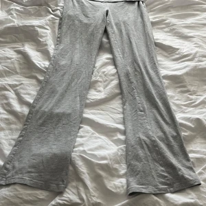 Grå vida mjukisbyxor från Gina Tricot - Säljer ett par grå mjukisbyxor från Gina Tricot med utsvängda ben. Byxorna är i mjukt bomullsmaterial och har en bekväm passform med normal midja. Perfekta för en avslappnad stil.