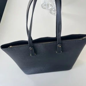Damväska - Hej, hjälper mamma att rensa garderoben. Säljer denna väska i färgen svart som är enkel och snygg och funkar till alla tillfällen. Väskan är i bra skick och säljs till ett riktigt bra pris pågrund av ingen användning längre. Först till kvarn!