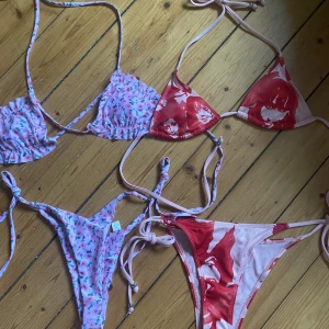 Två trendiga bikinis med knyt - Säljer två snygga bikinis i triangelmodell. Ena setet är ljusrosa med små körsbärsmönster och knyt i sidorna, andra är röd och vit med coolt ansiktsmönster och ribbad struktur. Båda har tunna band och passar perfekt till sommaren. Superfina färger och detaljer! Den rosa bikinin är aldrig använd och den röda är använd max 2 gånger!🩷❤️50kr för en eller 80kr för båda❤️
