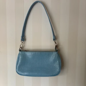 Ljusblå axelväska från Gina Tricot - Säljer en ljusblå axelväska från Gina Tricot 🩵Väskan har avtagbar axelrem och stängs med dragkedja. Ett stort fack och ett mindre fack med dragkedja i väskan🌸 