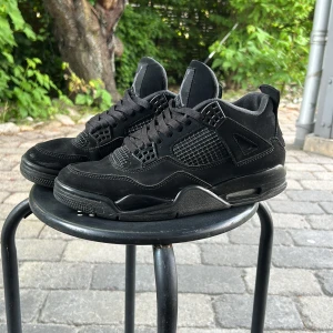 Svarta jordan 4s black cats - Säljer ett par jordan 4s black cats med inga skador förutom lite slitage på under sulan men ingenting som synd vid användning helt perfekta för sommaren eller vintern ( pris kan diskuteras)