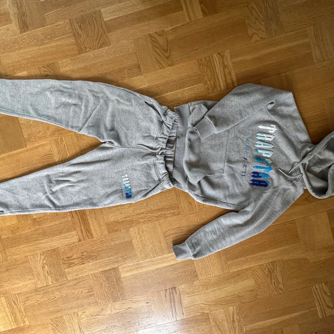 Grått Set Trapstar hoodie + byxor med blå brodyr - 1